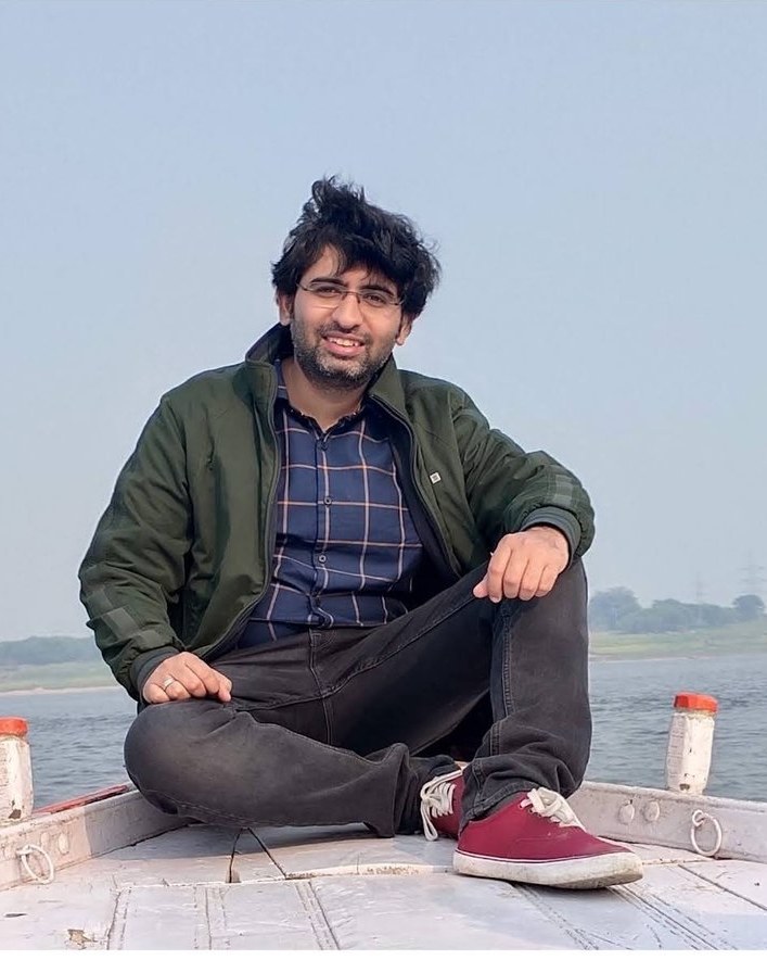 Akshay Gulati sitting at the bow of a boat on the Ganga